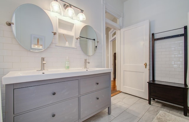 1209 Rosenberg St, Galveston, TX 77550 - bathroom with double vanity, marble look tile flooring, and backsplash