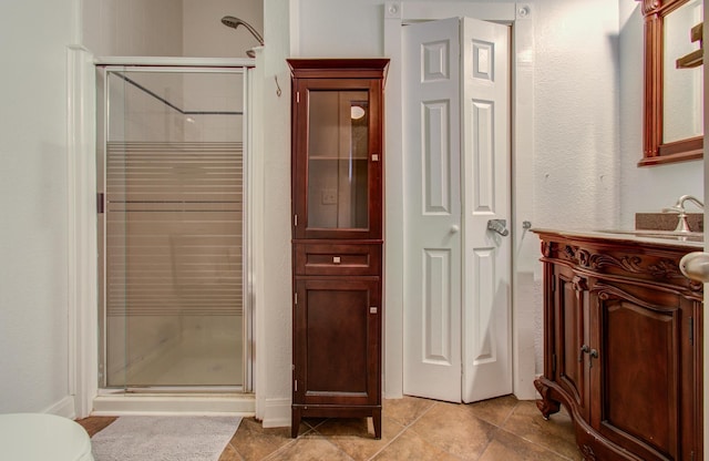 bathroom featuring a shower with door and vanity