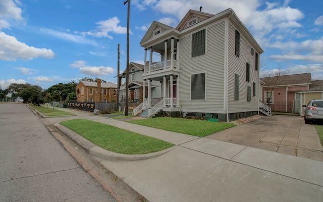 view of front of property with a front lawn and a balcony