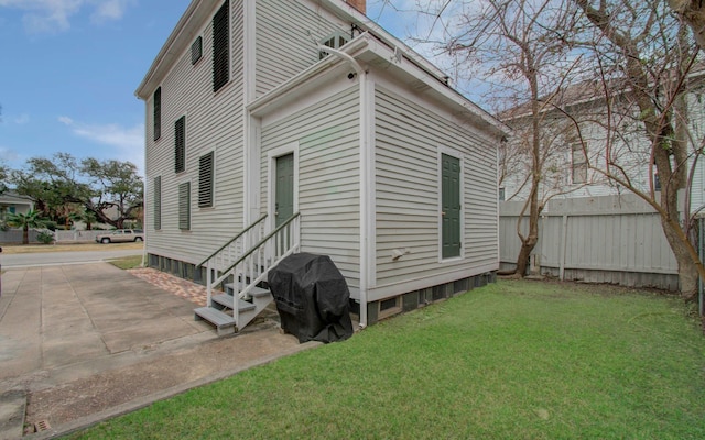 rear view of house featuring a lawn and a patio