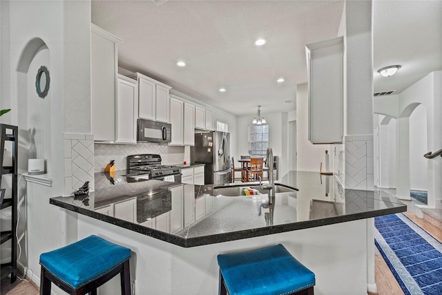 kitchen featuring kitchen peninsula, a breakfast bar area, and black appliances