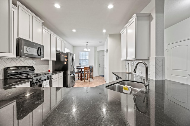 kitchen with sink, black appliances, and white cabinets