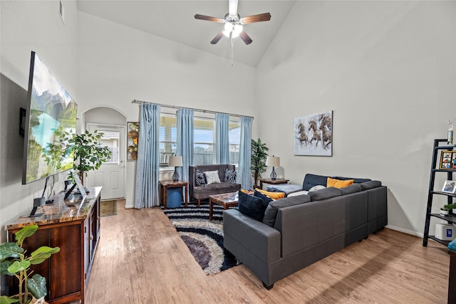 living room with ceiling fan, high vaulted ceiling, and light hardwood / wood-style floors