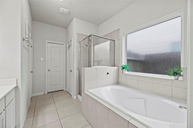 bathroom featuring tile patterned flooring, vanity, and plus walk in shower