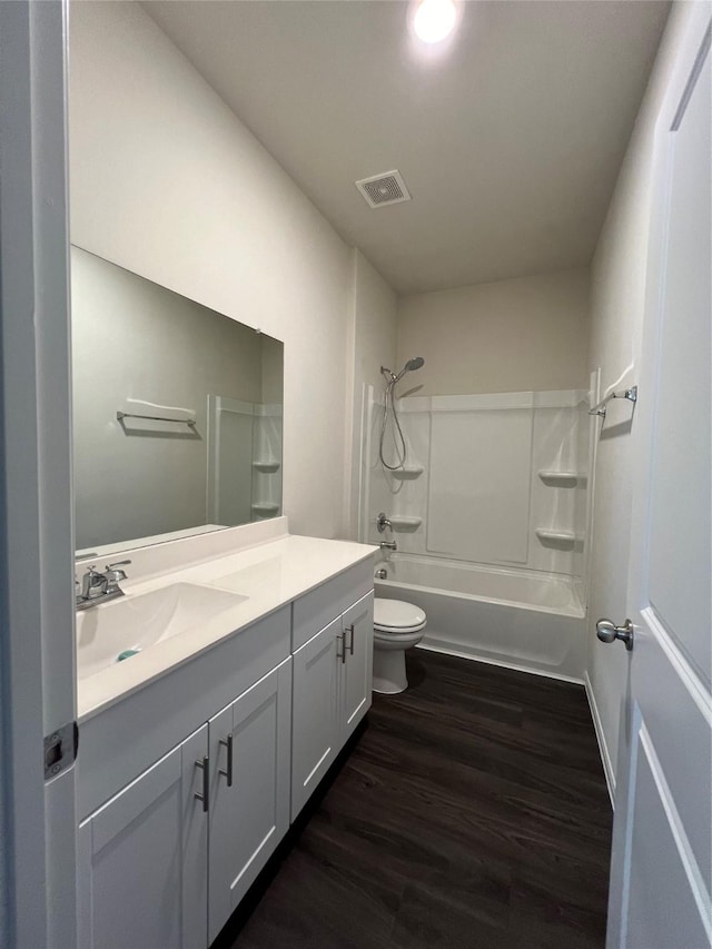 full bathroom featuring wood-type flooring, bathtub / shower combination, vanity, and toilet