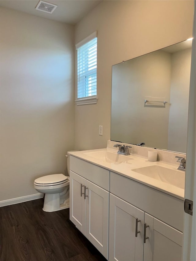 bathroom with hardwood / wood-style flooring, vanity, and toilet