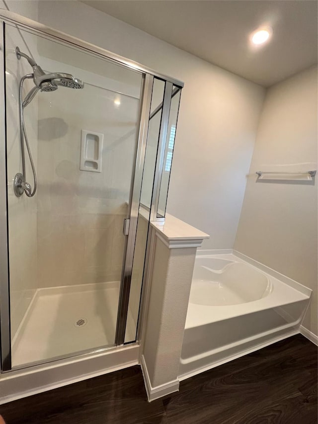 bathroom featuring wood-type flooring and separate shower and tub