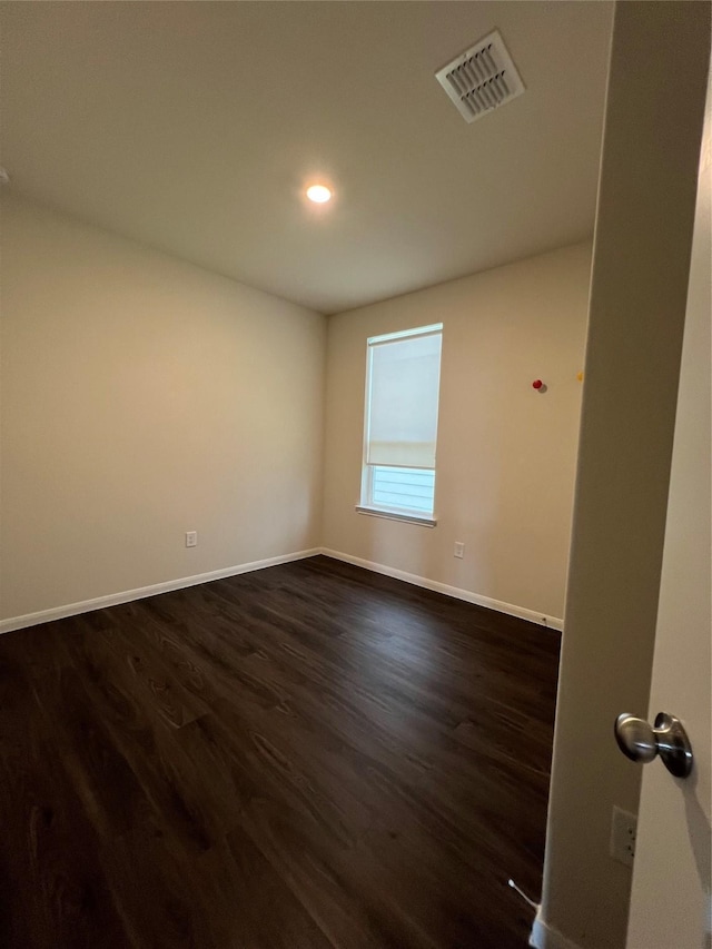 unfurnished room with dark hardwood / wood-style flooring