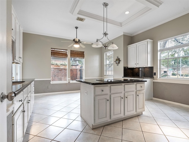 kitchen featuring light tile patterned flooring, a center island, a raised ceiling, and white cabinets