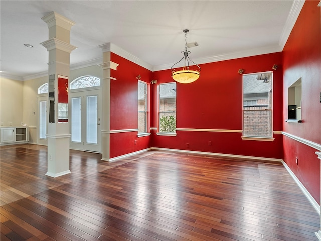 empty room featuring ornate columns, crown molding, and dark hardwood / wood-style flooring