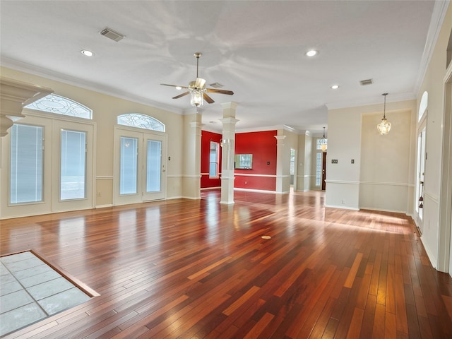 unfurnished living room featuring crown molding, decorative columns, and hardwood / wood-style flooring