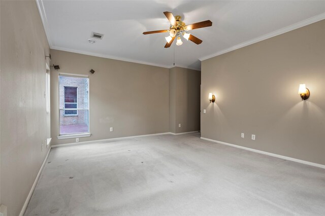 spare room with ceiling fan, ornamental molding, and light carpet