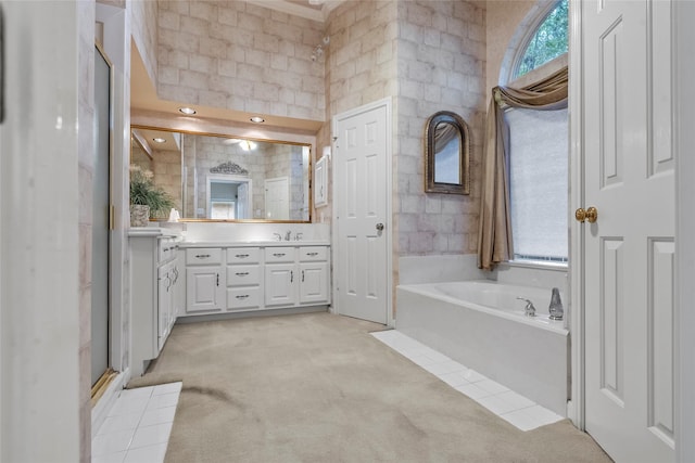 bathroom featuring vanity, plus walk in shower, and a healthy amount of sunlight