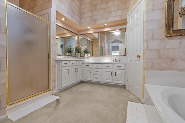 bathroom with vanity and shower with separate bathtub