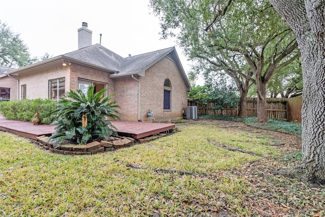 view of property exterior featuring cooling unit, a deck, and a lawn