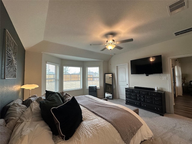 bedroom with carpet floors, visible vents, ceiling fan, and a textured ceiling