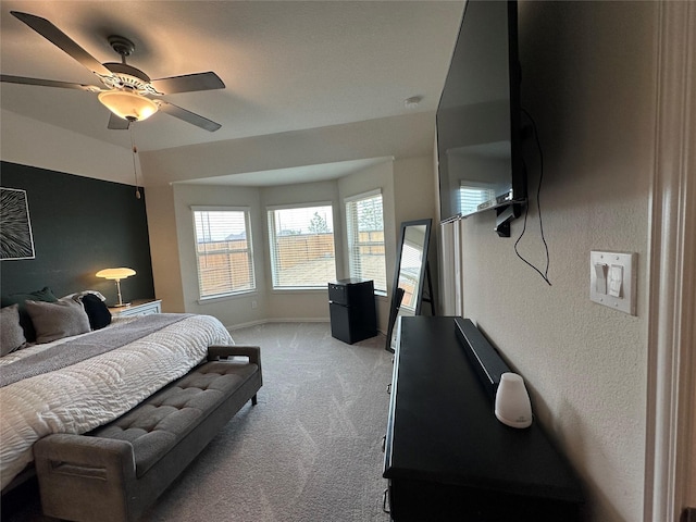 bedroom featuring baseboards, ceiling fan, and light colored carpet