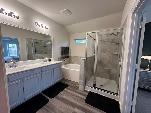 ensuite bathroom with a stall shower, wood finished floors, a sink, and ensuite bathroom