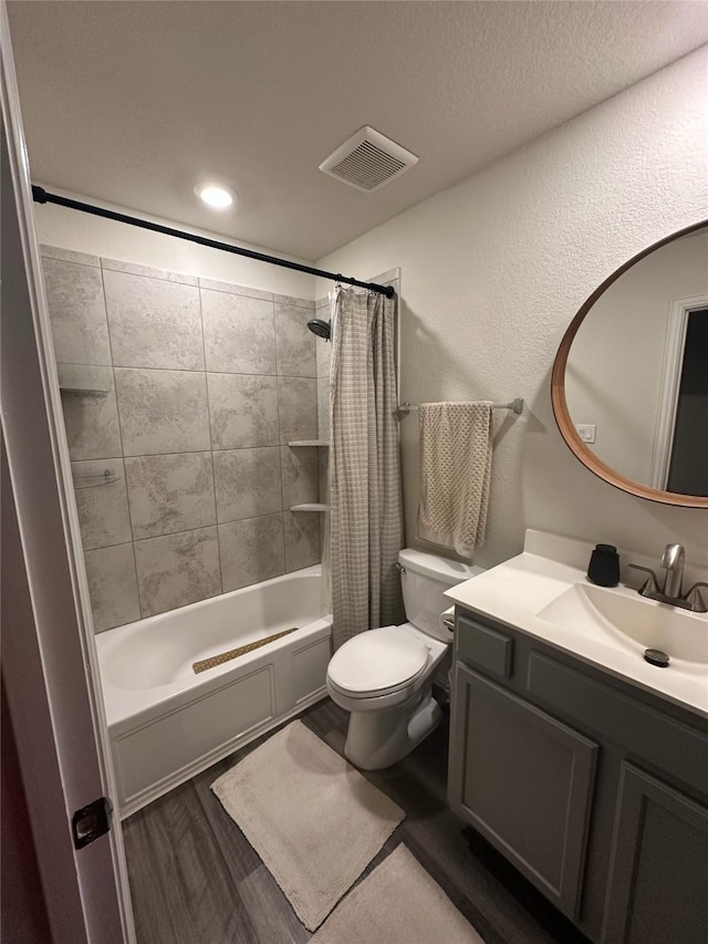 full bathroom featuring shower / bath combo, visible vents, toilet, wood finished floors, and vanity