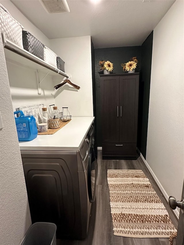 clothes washing area with laundry area, baseboards, visible vents, dark wood finished floors, and washer and dryer