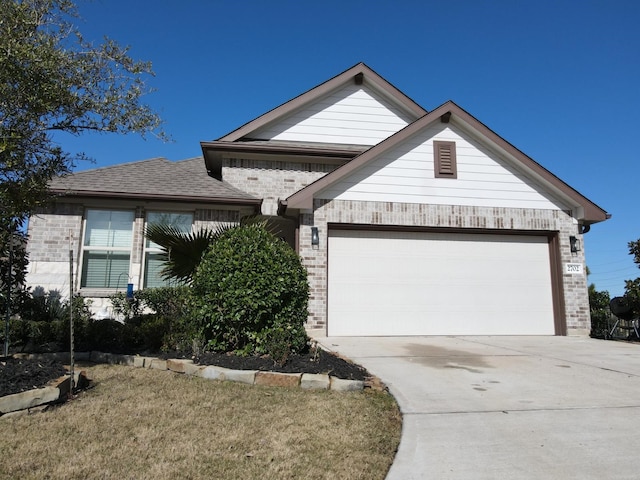 view of front of house with driveway, brick siding, roof with shingles, and an attached garage