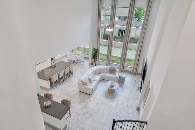 living room featuring ceiling fan and a high ceiling