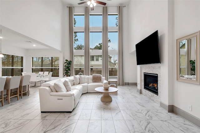 living room featuring ceiling fan and a high ceiling