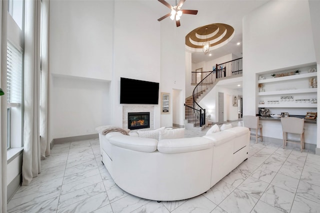 living room with ceiling fan and a towering ceiling