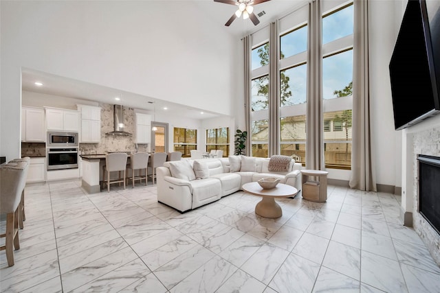 living room with a towering ceiling and ceiling fan