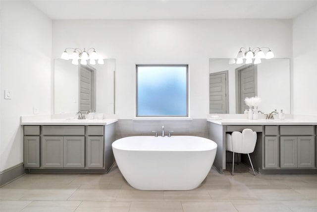 bathroom with a washtub, vanity, and tile patterned flooring