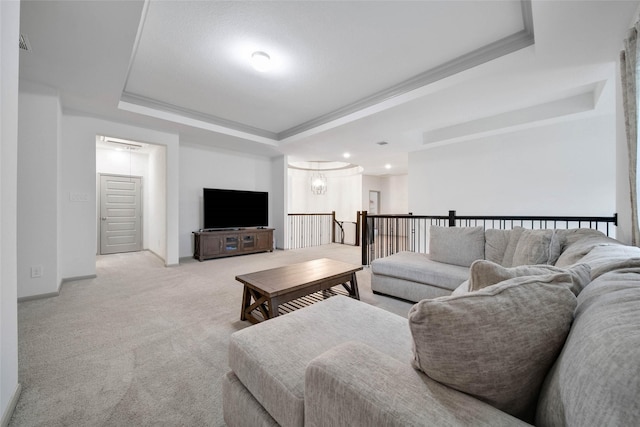 carpeted living room featuring a raised ceiling, crown molding, and a notable chandelier