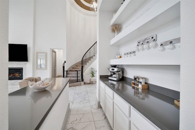 bar featuring white cabinetry and a high ceiling