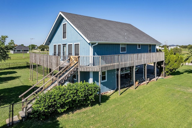 back of property with a wooden deck and a lawn