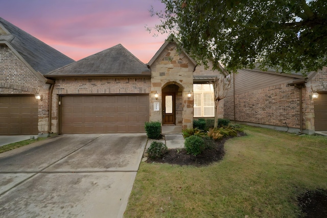 view of front of home with a garage and a lawn