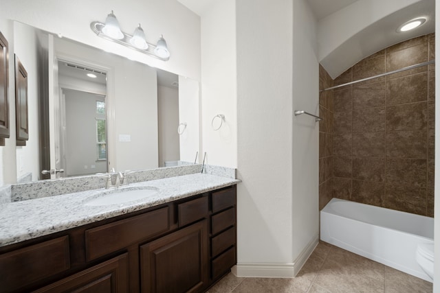 full bathroom featuring tile patterned flooring, vanity, tiled shower / bath combo, and toilet