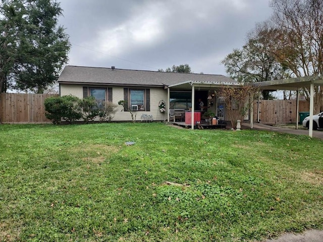 rear view of house featuring a carport and a yard