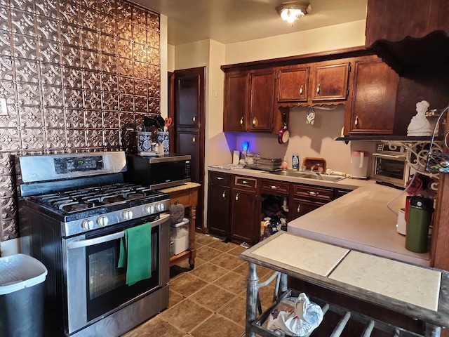 kitchen with appliances with stainless steel finishes, sink, and light tile patterned floors