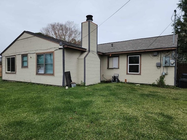 rear view of house featuring a yard