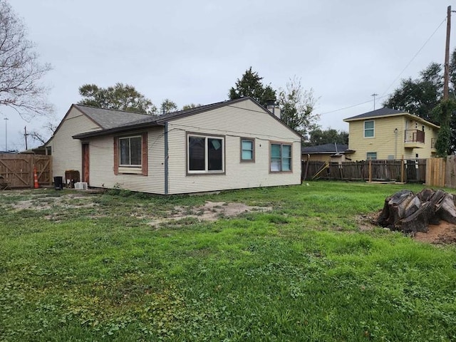 rear view of property featuring a yard