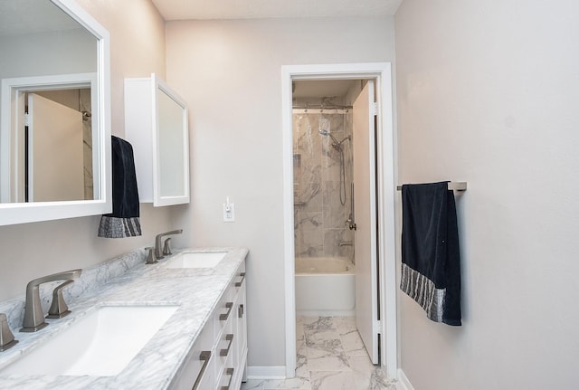 bathroom featuring marble finish floor, double vanity, a sink, and baseboards