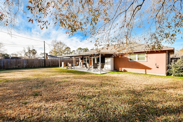 back of property featuring a yard, fence, and a patio