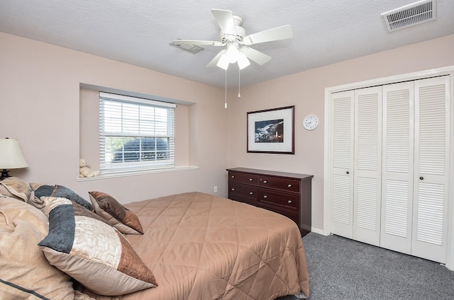 bedroom featuring visible vents, ceiling fan, a textured ceiling, carpet flooring, and a closet