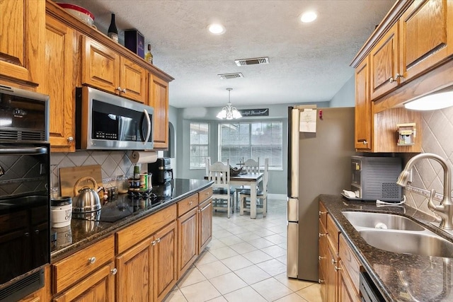 kitchen with light tile patterned flooring, backsplash, sink, and black appliances