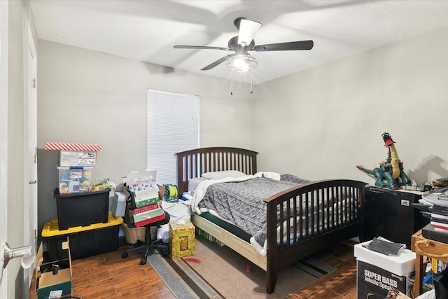 bedroom with dark hardwood / wood-style floors and ceiling fan