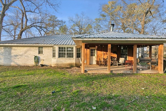 rear view of property featuring a yard and a patio area