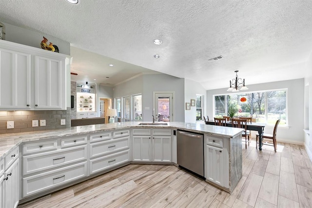 kitchen with dishwasher, sink, white cabinets, and kitchen peninsula