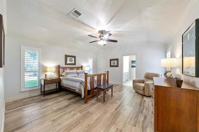 bedroom featuring multiple windows, a textured ceiling, and light wood-type flooring