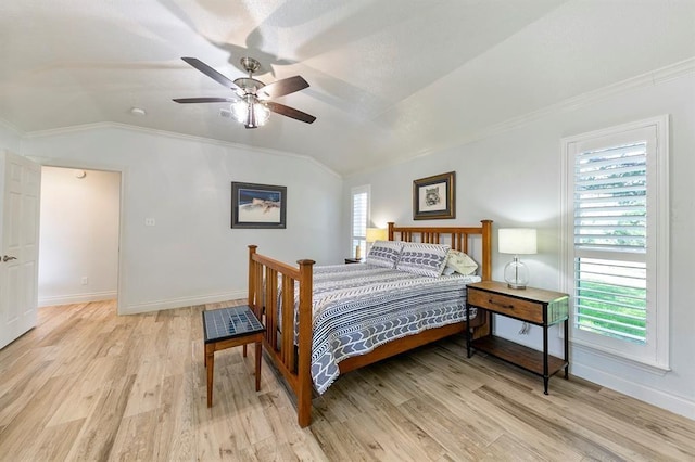 bedroom featuring ceiling fan, ornamental molding, vaulted ceiling, and light wood-type flooring