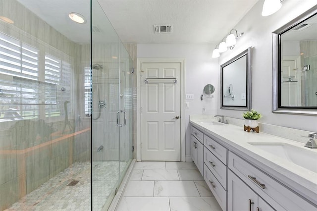 bathroom featuring vanity, a shower with shower door, and a textured ceiling