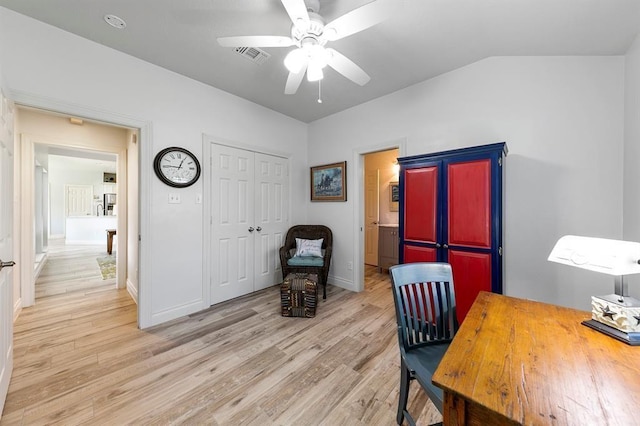 home office featuring vaulted ceiling, ceiling fan, and light hardwood / wood-style flooring